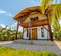 ZARIA GARDEN BUNGALOWS - Exotická výstavba domov v tropickom prostredí so slamenou strechou a drevenými prvkami.