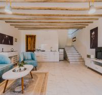 ZARIA GARDEN BUNGALOWS - Interiér s dreveným stropom, modrým nábytkom, schodmi a svetlou dlažbou. Výstavba domov.