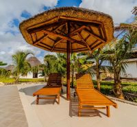 ZARIA GARDEN BUNGALOWS - Drevené lehátka pod slameným slnečníkom pri bazéne obklopené exotickou záhradou. Skvelá výstavba domov.