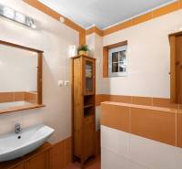 Priestranný 7-izbový dom na skok od centra – Senec - Kúpeľňa v rodinnom dome s umývadlom, keramickými dlaždicami a dreveným nábytkom.