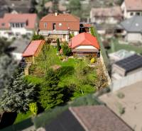 Priestranný 7-izbový dom na skok od centra – Senec - Rodinný dom v Senci obklopený záhradou a stromami, s červenou strechou.