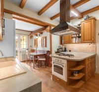 Priestranný 7-izbový dom na skok od centra – Senec - Kuchyňa v rodinnom dome s drevenými prvkami, varnou doskou a jedálenským stolom.