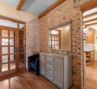 Priestranný 7-izbový dom na skok od centra – Senec - Interiér rodinného domu s tehlovou stenou, drevenými dverami a nábytkom.