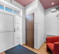 Priestranný 7-izbový dom na skok od centra – Senec - Interiér rodinného domu s výrazným červeným kreslom a vstupnými dverami.