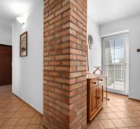 Priestranný 7-izbový dom na skok od centra – Senec - Vstupná hala Rodinného domu s tehlovou stenou a dreveným nábytkom.