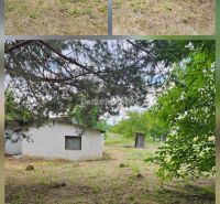 Jedinečný pozemok pod lesom v obci Sokolovce 675m2 – tiché miesto s ve - Záhrady v Sokolovciach s malou budovou, obklopené stromami a trávnatým porastom.