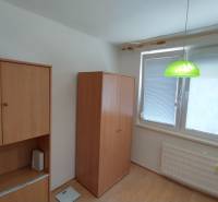 Na predaj 3-izbový byt v N. Zámkoch s balkónom. - Interiér 3-izbového bytu s drevenou skriňou a zelenou závesnou lampou.