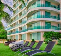PARADISE OCEAN VIEW PATTAYA - Výstavba bytov v Pattayi pri mori s ležadlami a palmami.