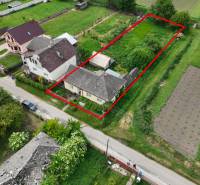 Dulovce - RODINNÝ DOM so 700 m2 POZEMKOM - Letecký pohľad na rodinný dom v Dulovciach s veľkou záhradou a okolím.