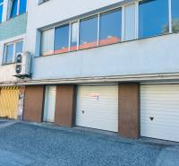 (16 m²) GARÁŽ NA PRENÁJOM V CENTRE - Garáže na Štefánikovom námestí v Spišskej Novej Vsi so vstupmi a reklamnou tabuľou.