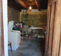 Na predaj stavebný pozemok 3655 m2 Zemianske Sady okr. Galanta  - Pracovný priestor v rodinnom dome s drevenými trámami, práčkou a stolom.