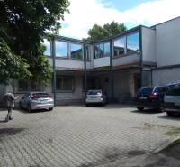 Administratívno-skladová budova Bratislava - Trnávka - Dvor s parkujúcimi autami pri výrobných priestoroch na Beckovskej ulici v Bratislave - Ružinove.