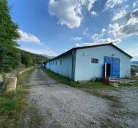 Výrobno - skladová hala Horný Moštenec - Sklady a haly v Považskej Bystrici, obklopené zeleňou a modrou oblohou.