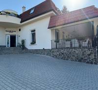 NA PREDAJ hotel s reštauráciou - Pohľad na budovu obklopenú zelenou, hotely ponúkajúce ubytovanie na nádvorí.