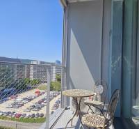 PRENÁJOM- 1i byt, klima, parking, loggia,Olivia Residence, Rožňavska - Balkón s kovovým stolom a stoličkami, výhľad na Rožňavskú ulicu v Bratislave.