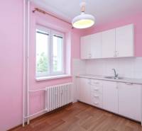 BÝVANIE NA HRADOM KOPCI - 3i byt, 90 m2 s balkónom, SVETLÁ ulica - Kuchyňa v 3-izbovom byte s bielou linkou, drevenou podlahou a ružovými stenami.