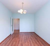 BÝVANIE NA HRADOM KOPCI - 3i byt, 90 m2 s balkónom, SVETLÁ ulica - Prázdna miestnosť v 3-izbovom byte s drevenou podlahou a lustrom.