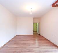 BÝVANIE NA HRADOM KOPCI - 3i byt, 90 m2 s balkónom, SVETLÁ ulica - Priestranná miestnosť s drevenou podlahou a bielymi stenami v 3-izbovom byte.