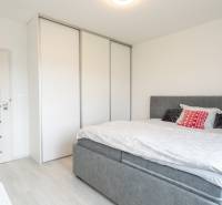 ZARIADENÝ - 3i v novostavbe 76 m2 + balkon - Trenčín - Spálňa v 3-izbovom byte s posteľou, skriňou a svetlými dverami.
