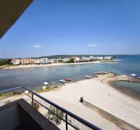 CHORVÁTSKO - Apartmány 1.rad od mora - SUKOŠAN, ZADAR - Výhľad z 1-izbového bytu v Sukošane s plážou a pobrežím na obzore.