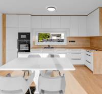 REZERVOVANÉ Krásny 4i RD 105m2, smart systém, záhrada, úplne nový - Kuchyňa v rodinnom dome s bielymi skrinkami, jedálenským stolom a drevenou podlahou.