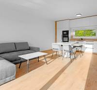 REZERVOVANÉ Krásny 4i RD 105m2, smart systém, záhrada, úplne nový - Obývacia izba s kuchynským kútom v rodinnom dome, s pohovkou a jedálenským stolom.