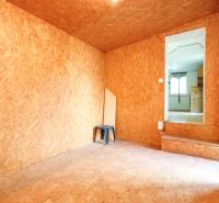  4i RD s pozemkom 269m2, Kálnica - NMnV - Izba s OSB doskami, stoličkou, oknom a rodinný dom na vidieku v pozadí.