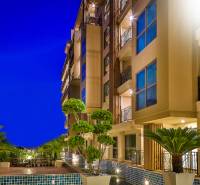 CITY GARDEN TROPICANA PATTAYA - Nočná výstavba bytov v Pattayi s osvetlenými balkónmi a zelenou okolitou výsadbou.