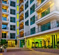 CITY GARDEN TROPICANA PATTAYA - Výstavba bytov v Pattayi: moderná budova s presklenými balkónmi a nočným osvetlením.