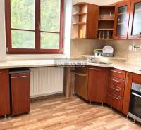 Predaj, trojizbový byt Michalovce - Kuchyňa v 3-izbovom byte s drevenou linkou, okno s výhľadom do zelene.