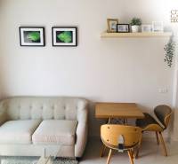 1 IZBOVÝ APARTMÁN (1 SPÁLŇA + 1 OBÝV. IZBA) CITY GARDEN TROPICANA  - Obývacia časť 2-izbového bytu s pohovkou, stolom a dekoráciami na stene.