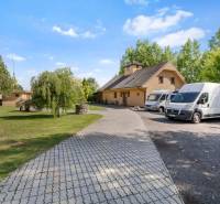 3 nehnuteľnosti na pozemku 4700m2 | Hamuliakovo  - V Hamuliakove na Kostolnej ulici vidno rodinný dom so záhradou a zaparkovanými vozidlami.