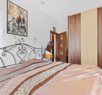 3 nehnuteľnosti na pozemku 4700m2 | Hamuliakovo  - Spálňa v rodinnom dome s kovovou posteľou, obrazmi a vstavanou skriňou.