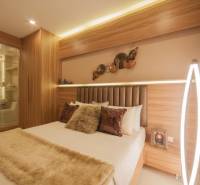 2 IZBOVÝ APARTMÁN (2 SPÁLNE + 1 OBÝV. IZBA) CITY GARDEN TOWER PATTAYA - Spálňa v 3-izbovom byte so zrkadlom, drevenými prvkami a jemným osvetlením.