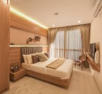 2 IZBOVÝ APARTMÁN (2 SPÁLNE + 1 OBÝV. IZBA) CITY GARDEN TOWER PATTAYA - Interiér 3-izbového bytu s elegantnou spálňou, dreveným nábytkom a veľkým oknom s pôsobivými závesmi.