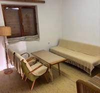PREDAJ, PODLUŽANY - VINIČNÝ DOMČEK S VINOHRADOM - Jednoduchý interiér s retro nábytkom, sedačkou, kreslami a dreveným konferenčným stolíkom.