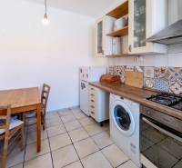 Zaujímavý 2i mezonet 65m2, s pavlačou, petfriendly KRÁTKODOBÝ PRENÁJOM - Kuchyňa v 2-izbovom byte s rustikálnym dreveným stolom a farebnými obkladačkami.