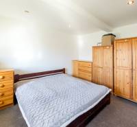 Zaujímavý 2i mezonet 65m2, s pavlačou, petfriendly KRÁTKODOBÝ PRENÁJOM - Spálňa v 2-izbovom byte s dreveným nábytkom a knižnicou.