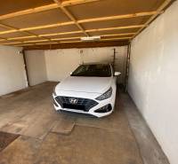 (36 m²) DVOJGARÁŽ ZÁPAD 1  - Interiér garáže s bielym autom značky Hyundai zaparkovaným vo vnútri.