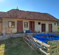 Predáme rodinný dom, pozemok 956 m2, Kmeťovo, okr. Nové Zámky - Rodinný dom v Kmeťove s prístavbou, nafukovací bazén a jednoduchý drevený plot.