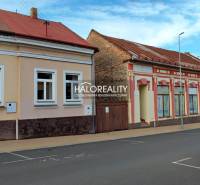 REZERVOVANÉ - Predaj, rodinný dom Lučenec, centrum -... - Rodinný dom v Lučenci so staršími fasádami a zaparkovaným červeným autom na ulici.