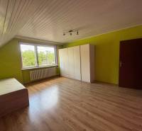 Dvojgeneračný 7i.rodinný dom v Záriečí vhodný na bývanie aj podnikanie - Izba v rodinnom dome s laminátovou podlahou, farebnými stenami, posteľou a šatníkom.
