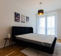 Skvelý slnečný 3i byt s balkónom v projekte METROPOLIS - Spálňa s posteľou a nočným stolíkom, doplnená o dekorácie na stene.