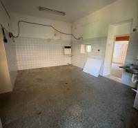 Obchodné priestory na predaj centrum mesta Šahy - Interiér obchodných priestorov so staršími obkladmi a dlažbou, prázdna miestnosť s umývadlom.