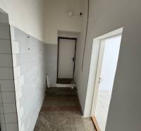 Obchodné priestory na predaj centrum mesta Šahy - Úzky chodba s dlaždicovými stenami a svetlom v obchodných priestoroch.
