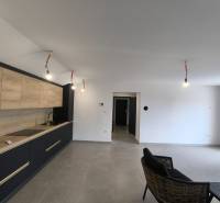 CHORVÁTSKO - Atraktívny apartmán (S6) - Mandre, ostrov Pag - Interiér 4-izbového bytu s minimalistickou kuchyňou a čiernym kreslom v obývačke.
