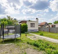 - EXKLUZÍVNE - REKREAČNÝ DOMČEK - ZLATÉ PIESKY  - Záhrada rodinného domu na Mokráň záhon v Bratislave-Ružinove s trampolínou a plotom.