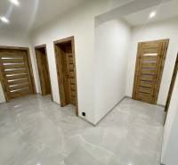 PREŠOV-LUKRATÍVNY RODINNÝ DOM,POZEMOK 820 m2, VLČIE DOLY - Chodba v rodinnom dome s drevenými dverami a lesklou dlažbou.