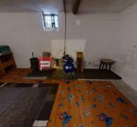 Na PREDAJ rodinný dom vo výbornej lokalite Bratislava - Ružinov - Suterén rodinného domu s malým oknom, koberec a vnútorné zariadenie vrátane kresla.