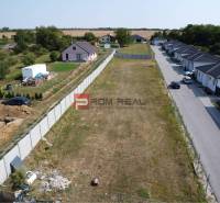 Stavebný pozemok so stavebným povolením a projektom na dvojdom - Pozemky - bývanie v Štefanovej, vedľa prázdna parcela, obklopené vidieckymi domami a zeleňou.